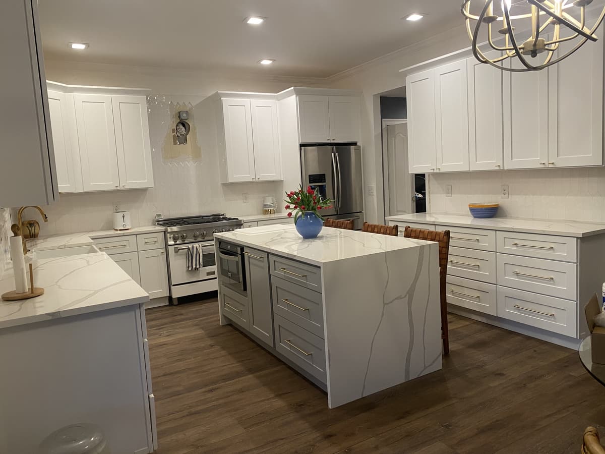 Karhan Construction & Remodeling — finished kitchen with quartz waterfall island and white shaker cabinets, Orlando area