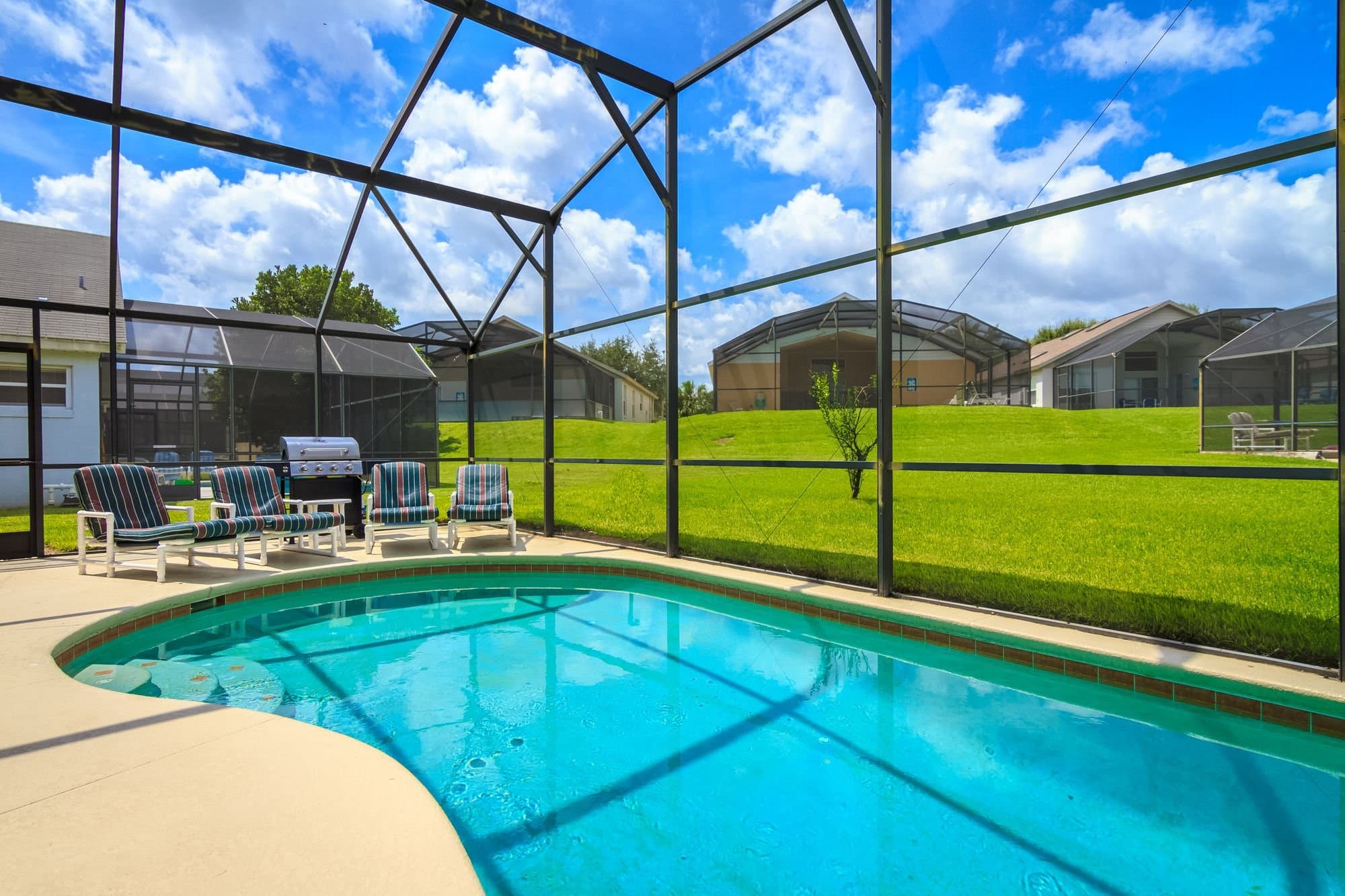 Aluminum screened pool cage over a Florida residential pool — licensed example photo of the enclosure style we build (not a Karhan project)