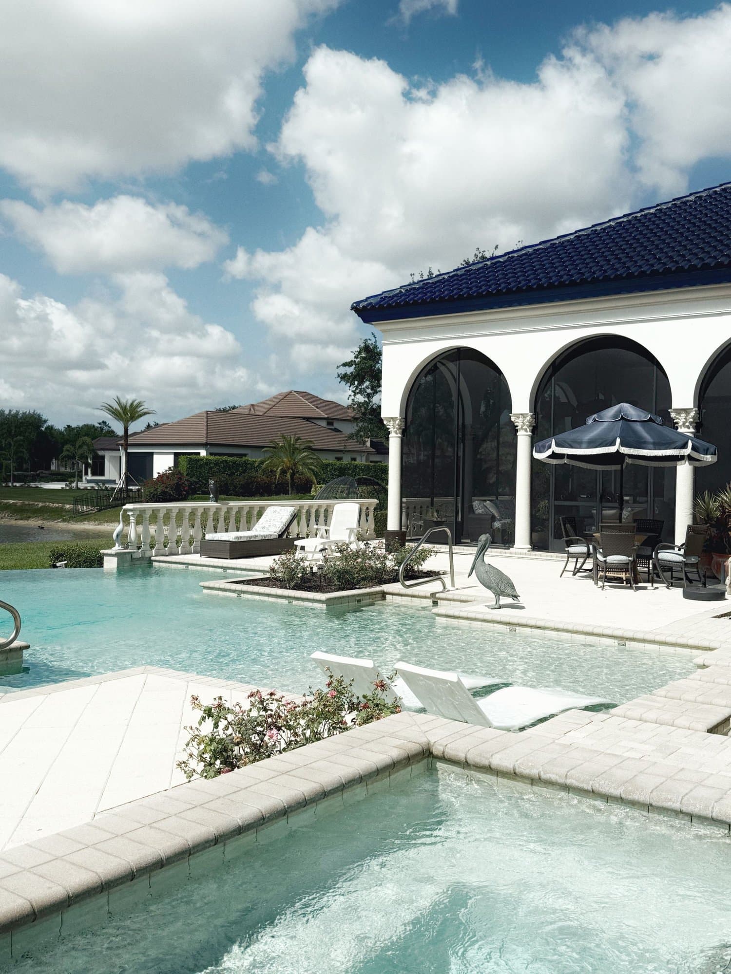 Florida poolside with screened arched lanai and palm trees — licensed example photo (not a Karhan project)