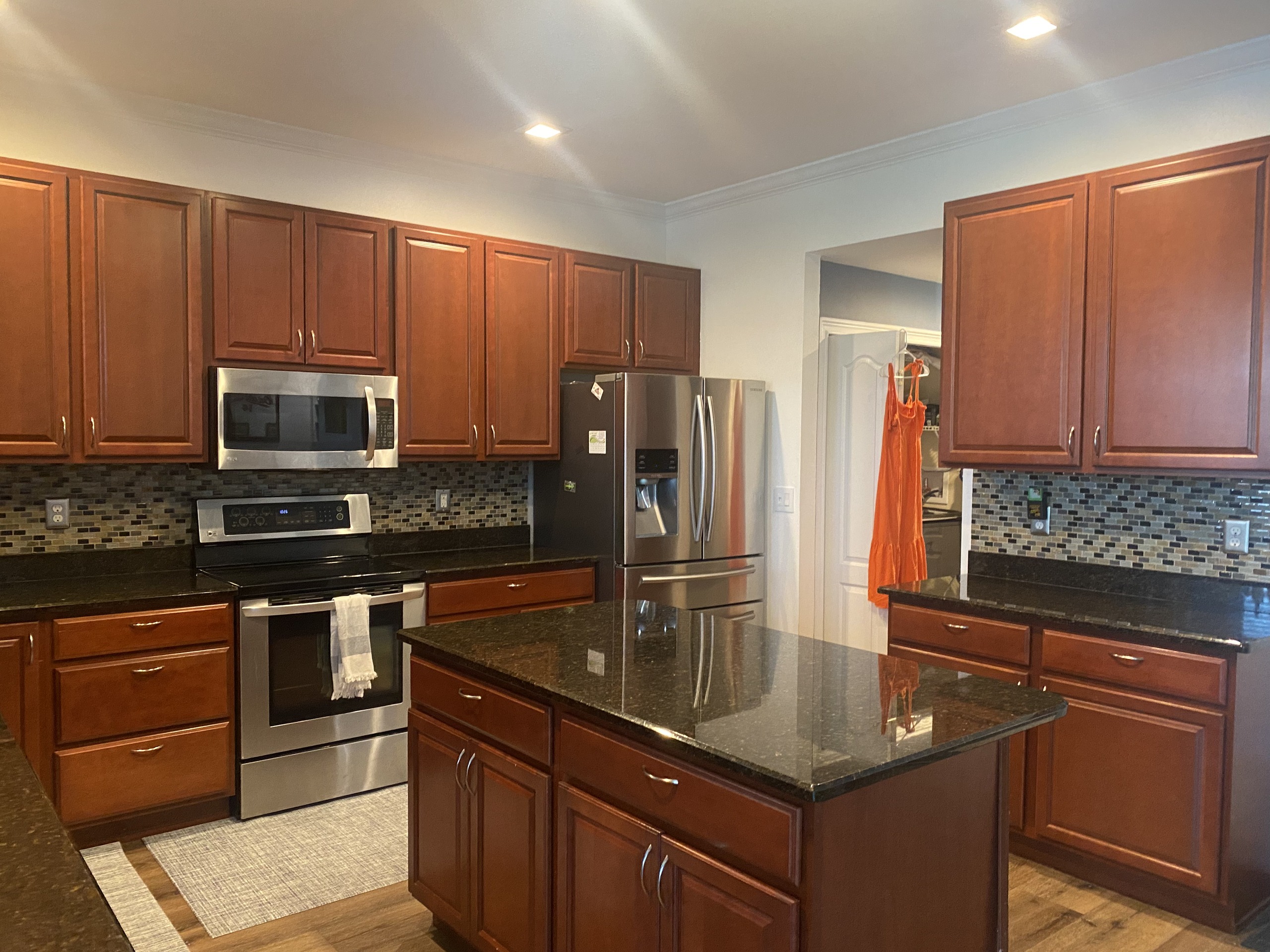 BEFORE — dated kitchen with cherry cabinets and mosaic backsplash (real Karhan project, Central Florida)